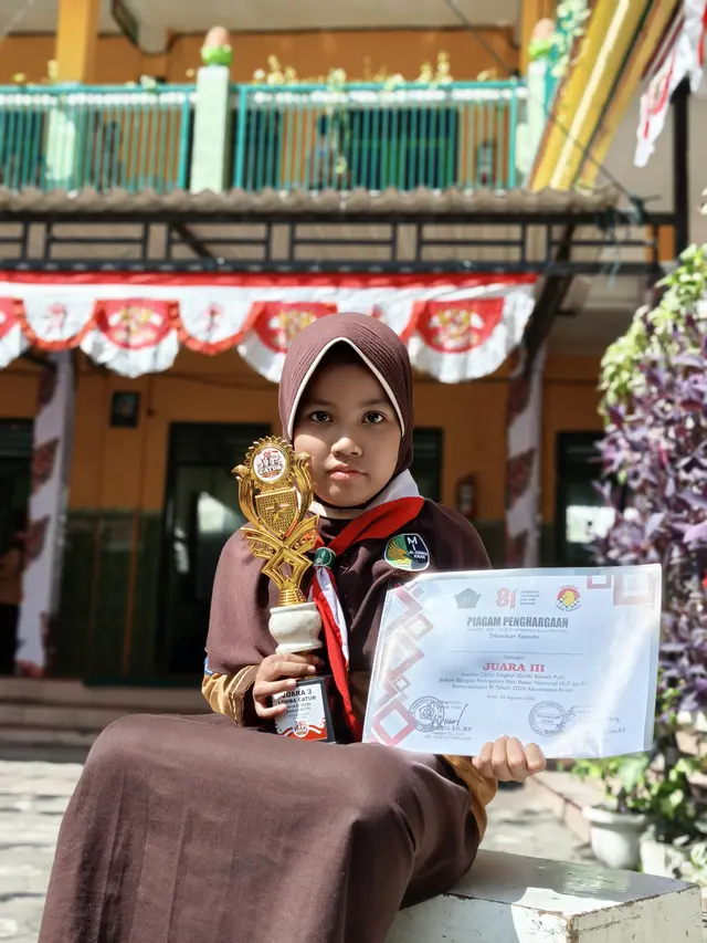 Siswi memegang piala dan piagam Juara III Lomba Catur