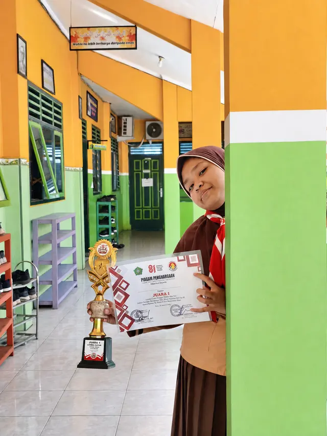 Siswi memegang trofi dan piagam Juara 1 Lomba Cerdas Cermat